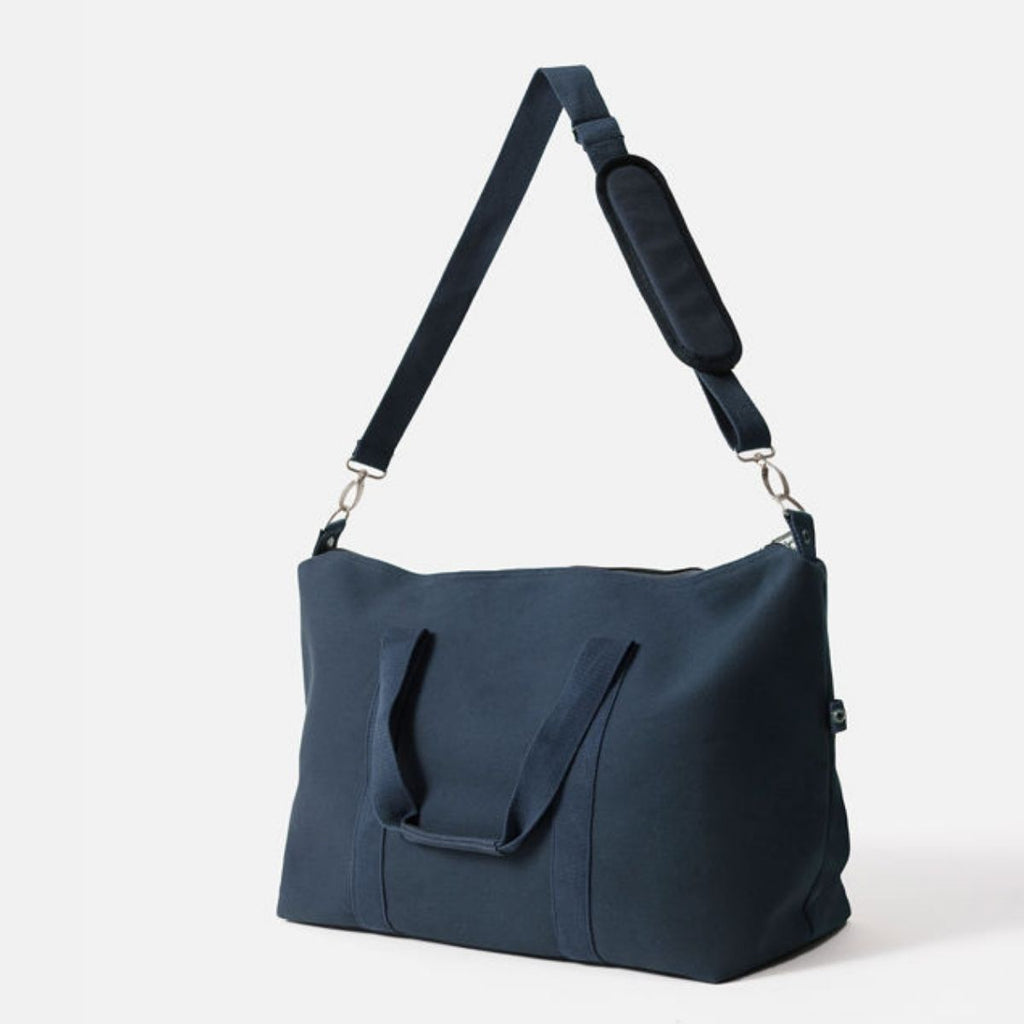 Navy blue handbag with a shoulder strap on a white background