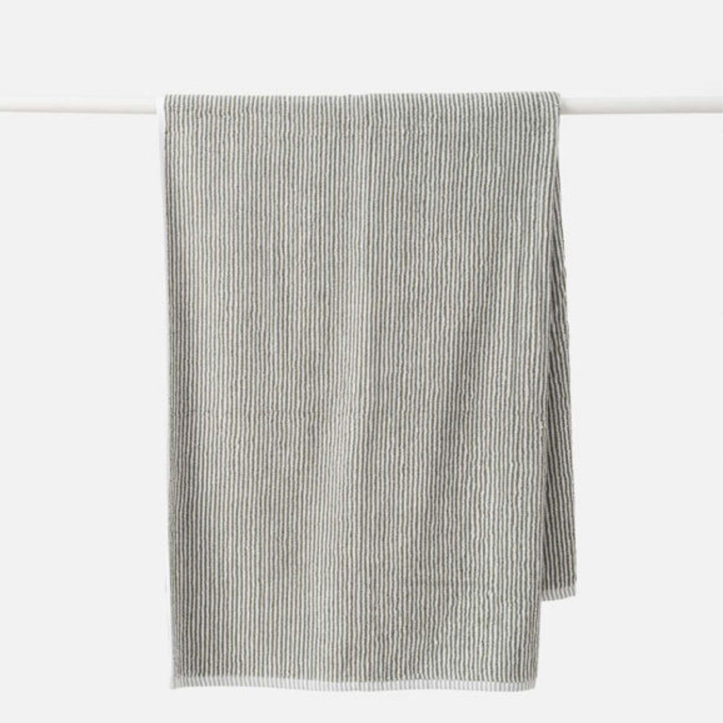 Striped towel hanging on a white rack against a white background