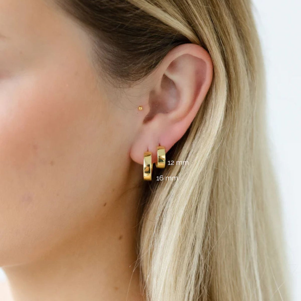 Gold hoop earrings worn by a person with blonde hair, showing ear and neck area.