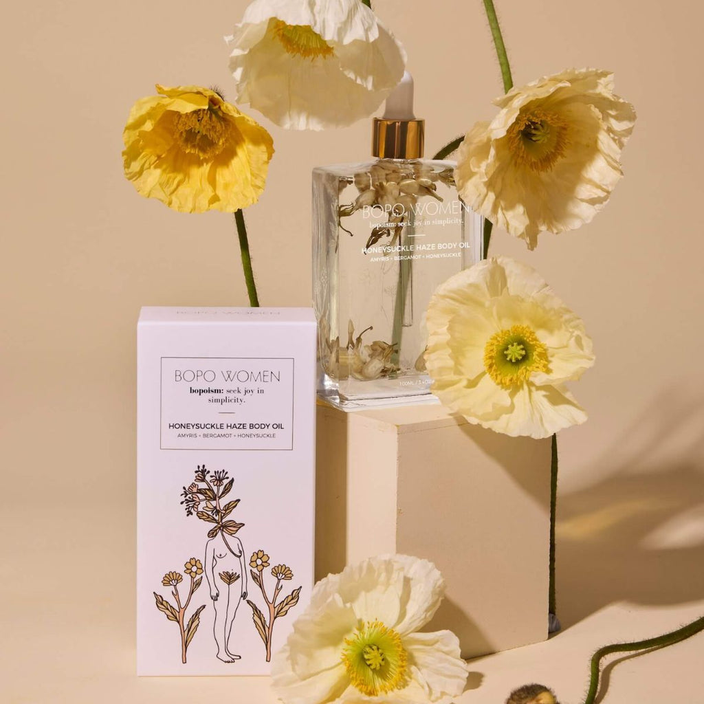 Bottle of BOPO WOMEN product with yellow flowers on a beige background