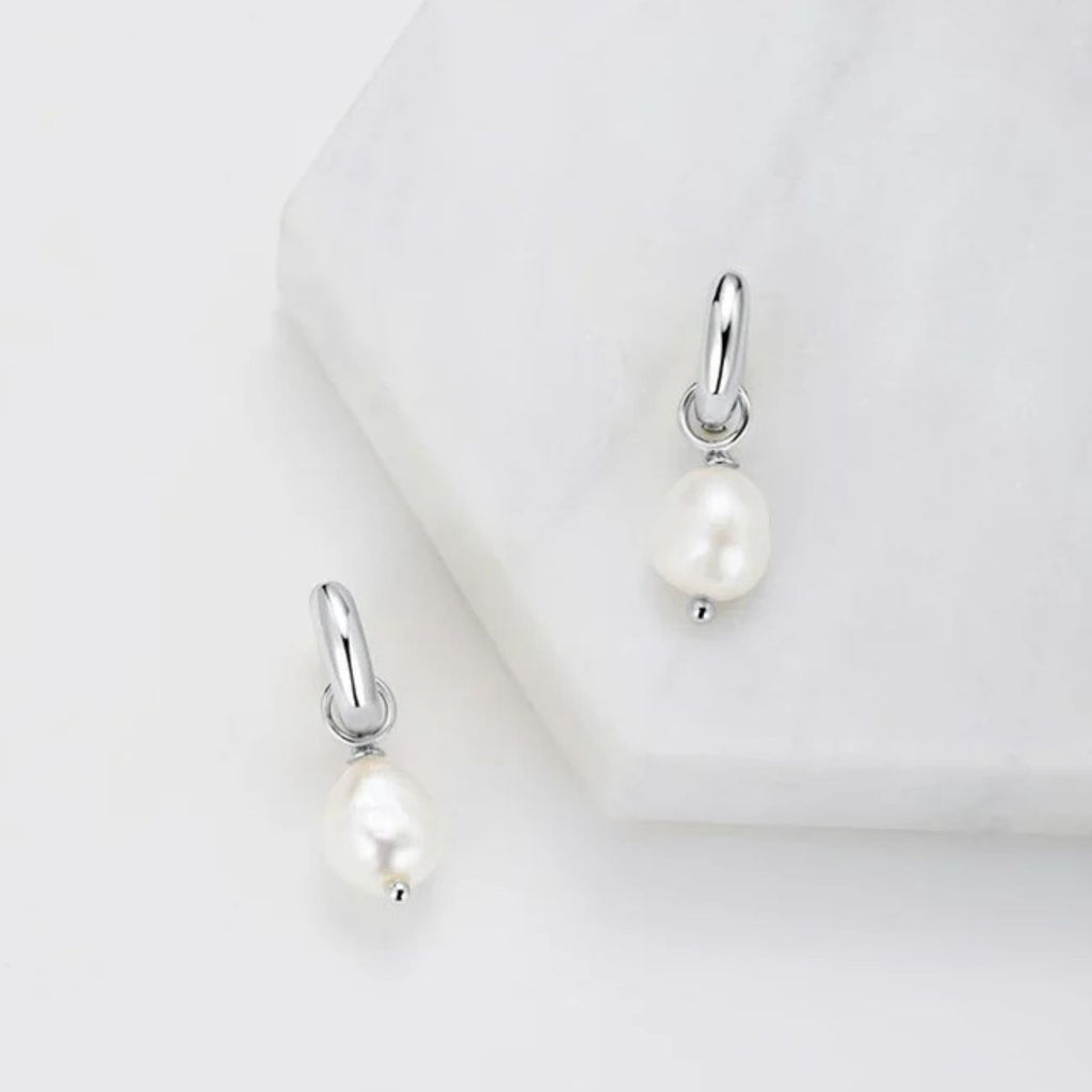 Pearl earrings with silver hooks on a white background