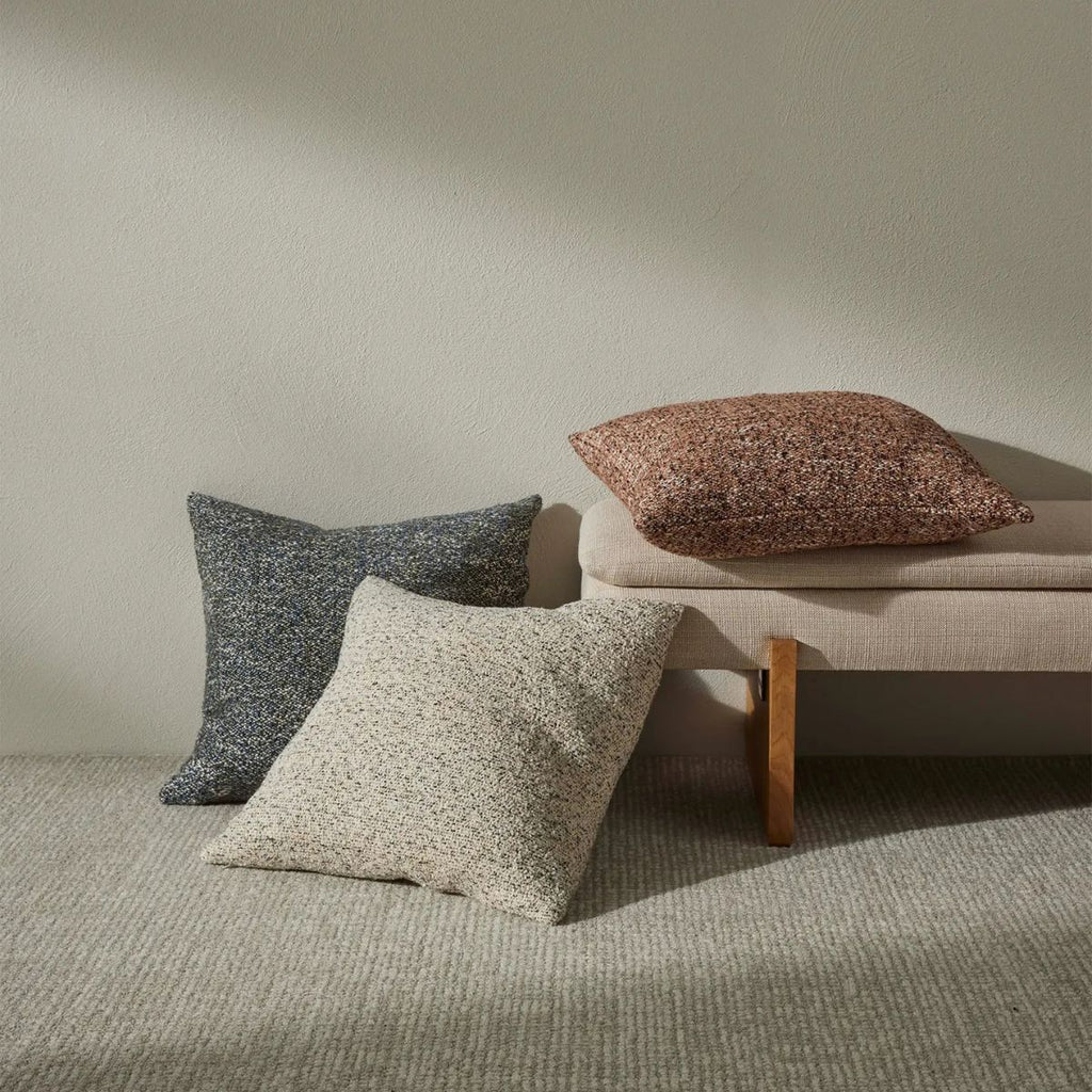 Three textured pillows on a neutral background