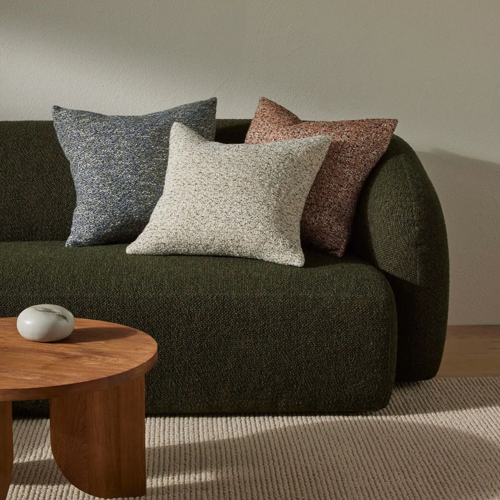 Green sofa with patterned cushions in a living room setting