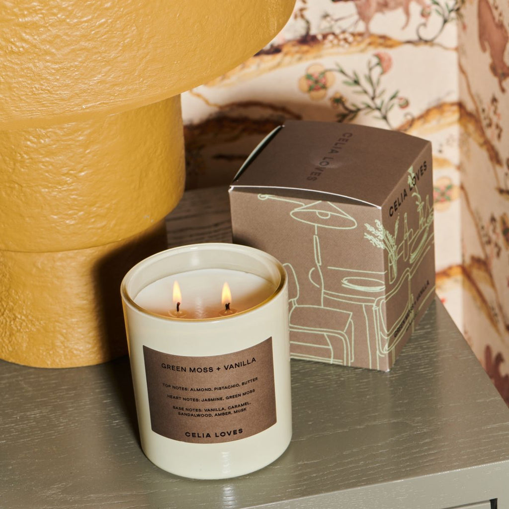 Candle with box on a table against a neutral background 