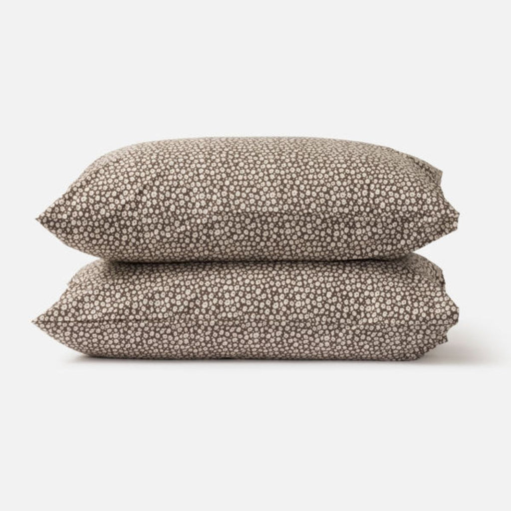 Pair of brown pillow cases with small flowers on them