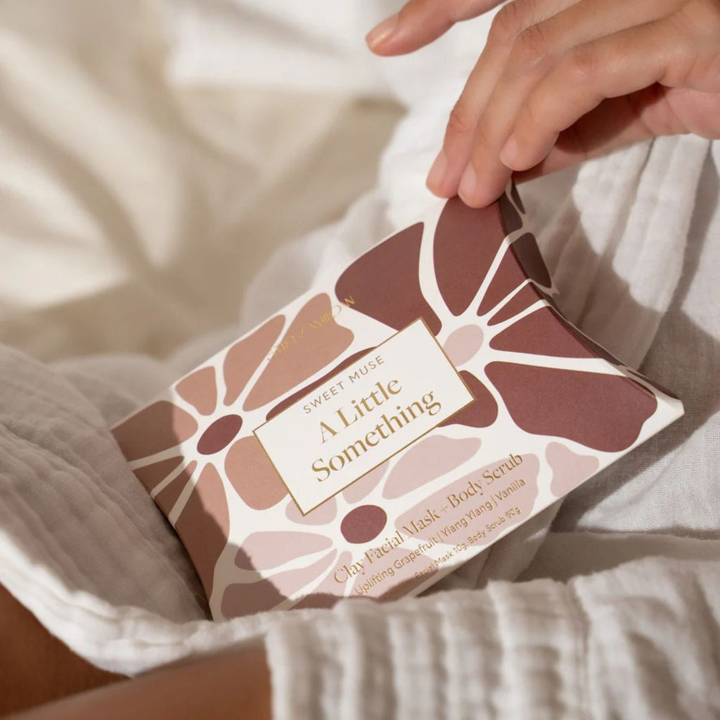 Hand holding a product packaging with floral design and text