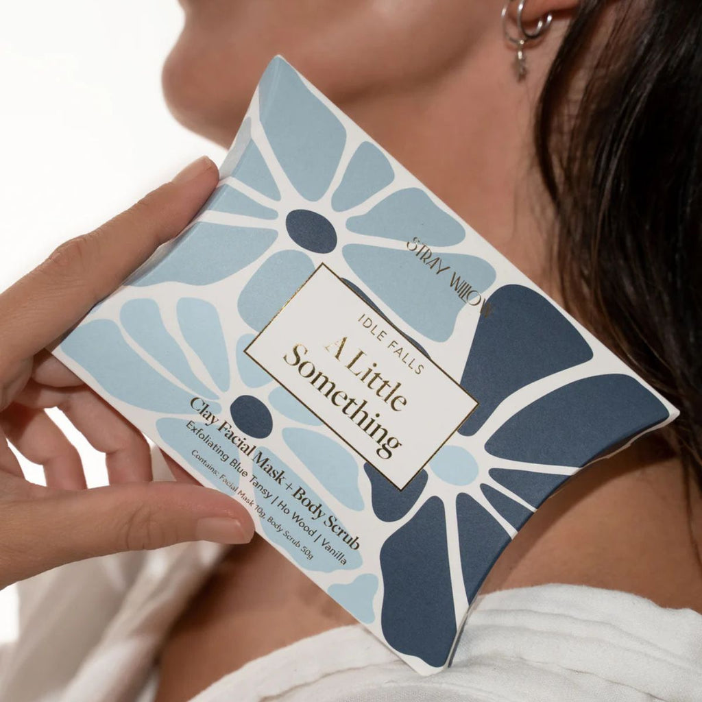 Person holding a product packaging with floral design and text