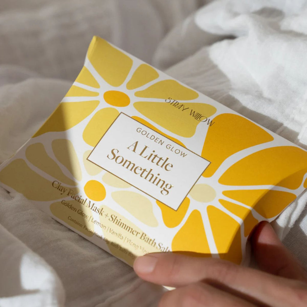 Product packaging with floral design and text on a light fabric background