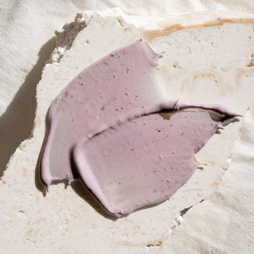 Purple cream smear on a textured white surface
