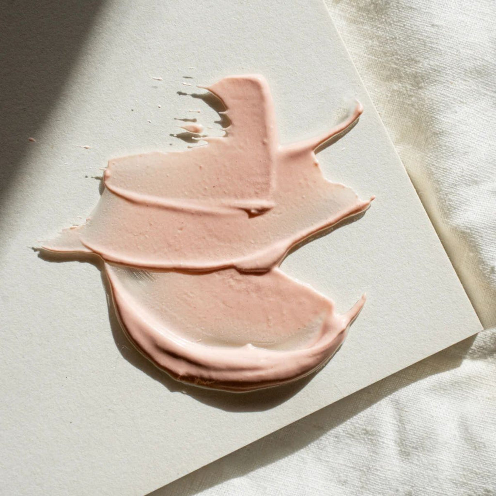 Pink cream or makeup product on a light surface