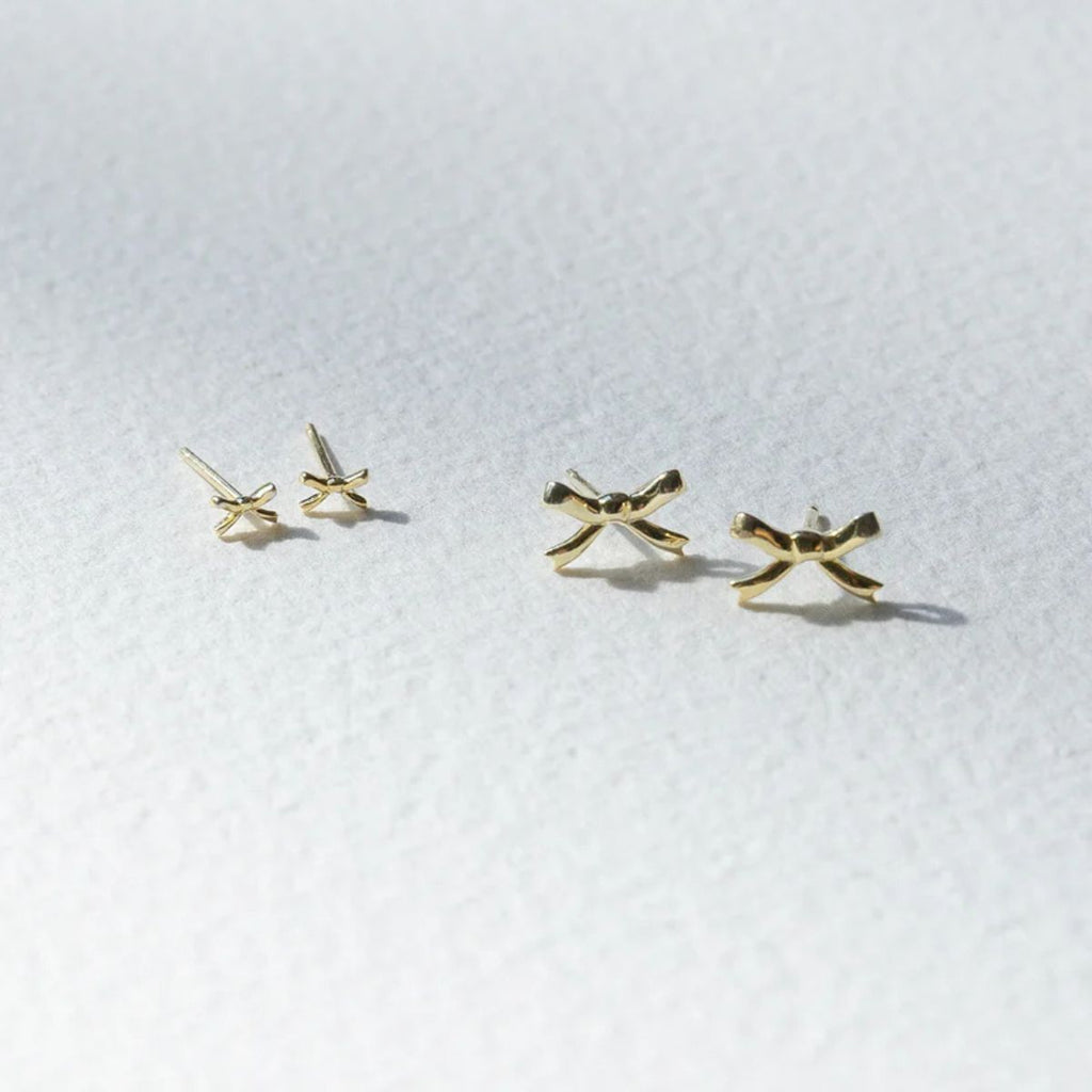 Gold X-shaped earrings on a white background