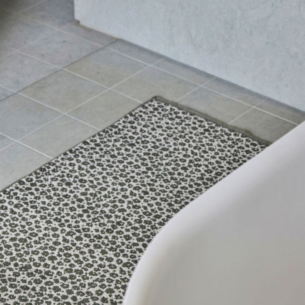 floral print bath mat on a tiled floor