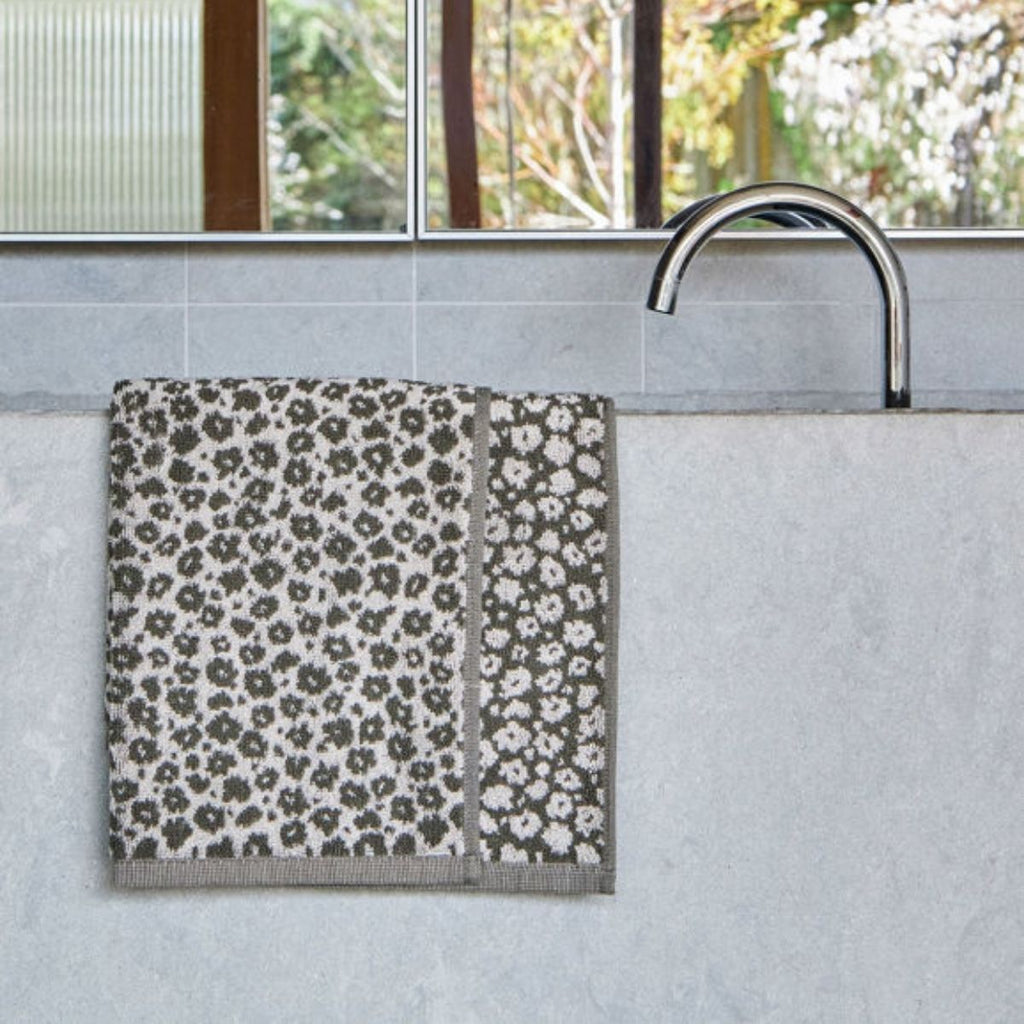 Patterned towel hanging on a towel rack in a bathroom setting.