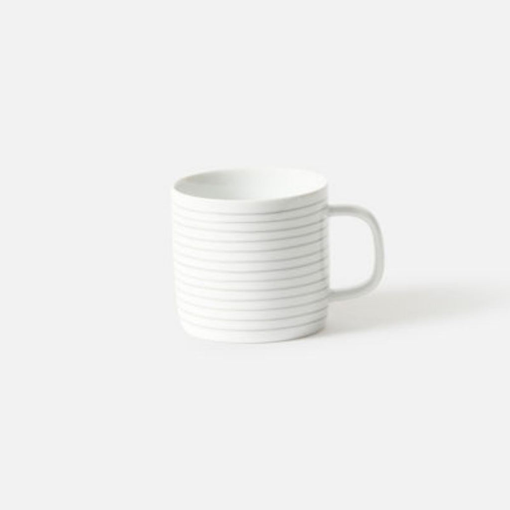 White ceramic mug with subtle design on a white background