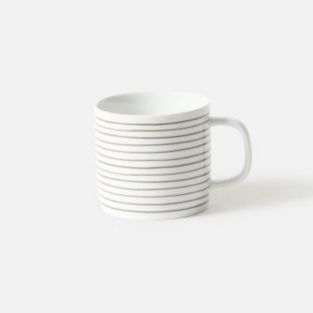 Stack of white mugs with thin black stripes on a white background