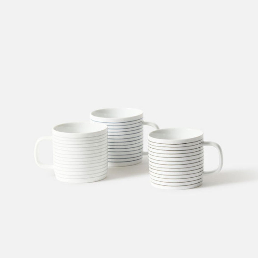 Set of white mugs with black stripes on a white background