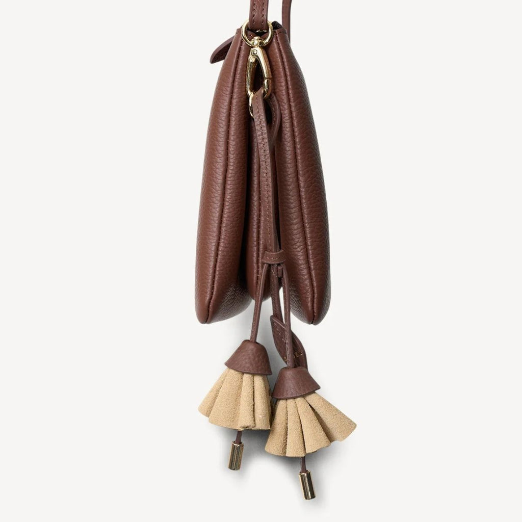 Brown leather bag with tassels on a white background