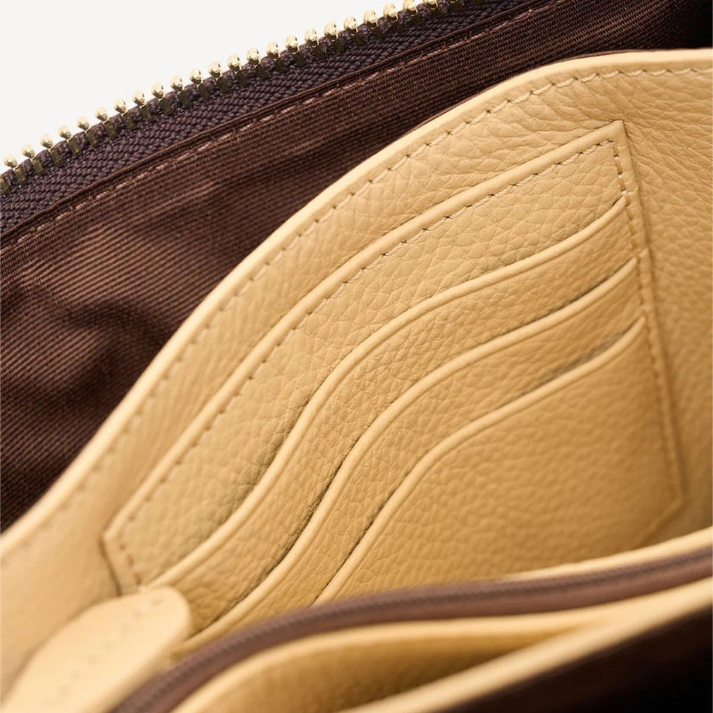Close-up of a beige leather pouch with a zipper