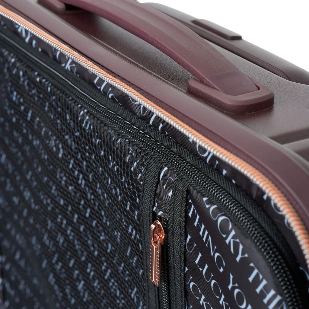 Close-up of a textured suitcase with a zipper and text detail.
