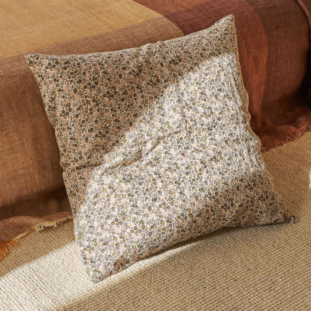 Floral-patterned pillow on a brown sofa