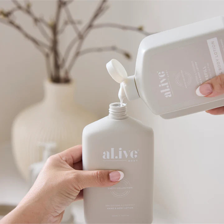 Person pouring a product from a white bottle labeled 'alive' into another white bottle.