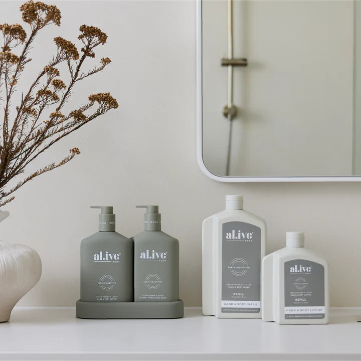 Bathroom shelf with 'alive' skincare products and a mirror.
