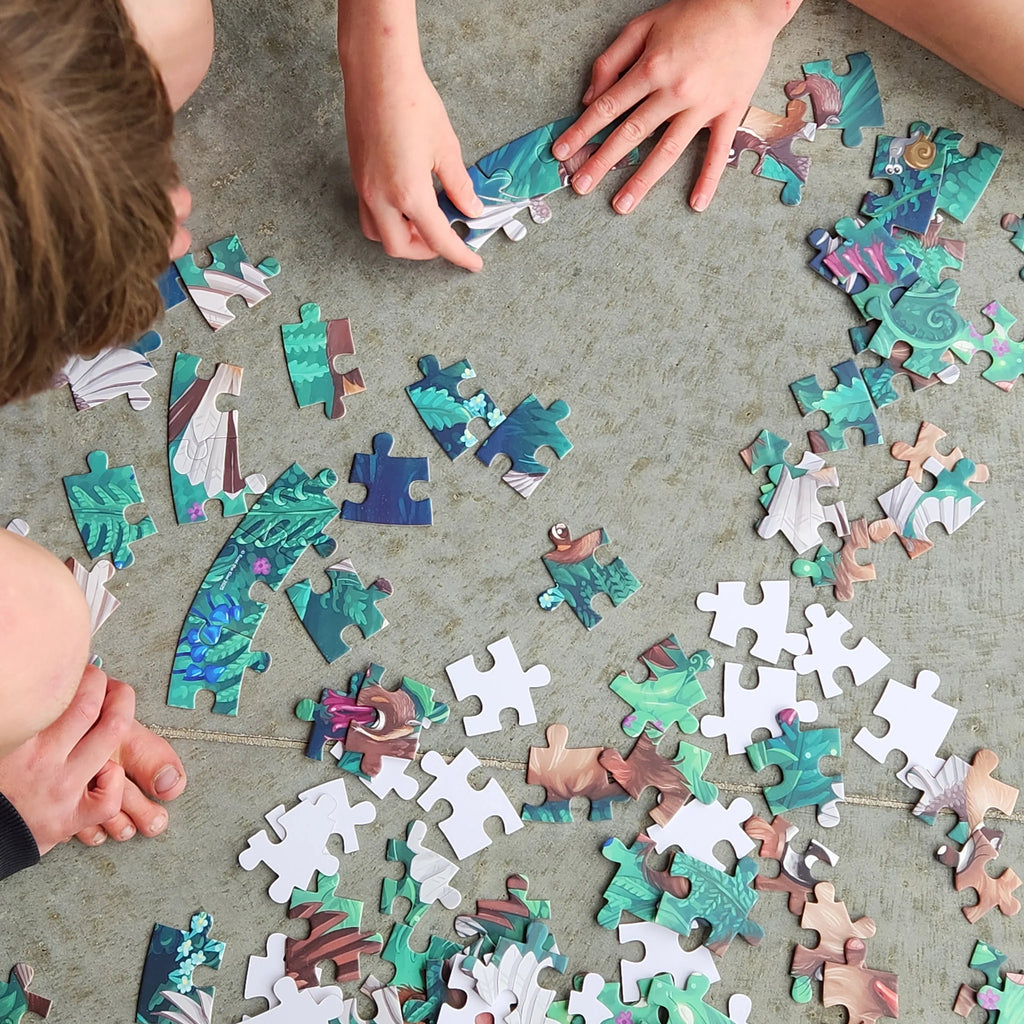 Children playing with a puzzle on a concrete floor