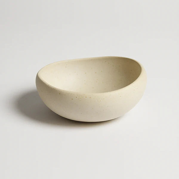 Beige ceramic bowl on a light gray background