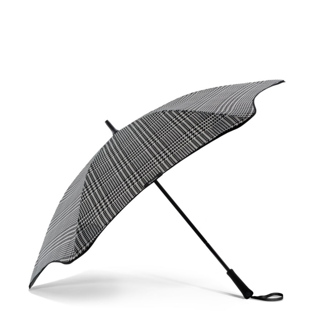 A black and white houndstooth patterned and black handle blunt Metro brand umbrella