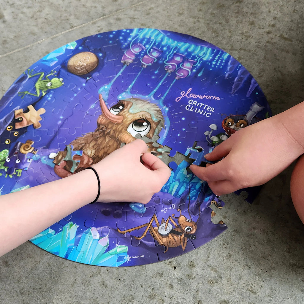 Children's hands working on a colorful puzzle with cartoon characters on a round table.