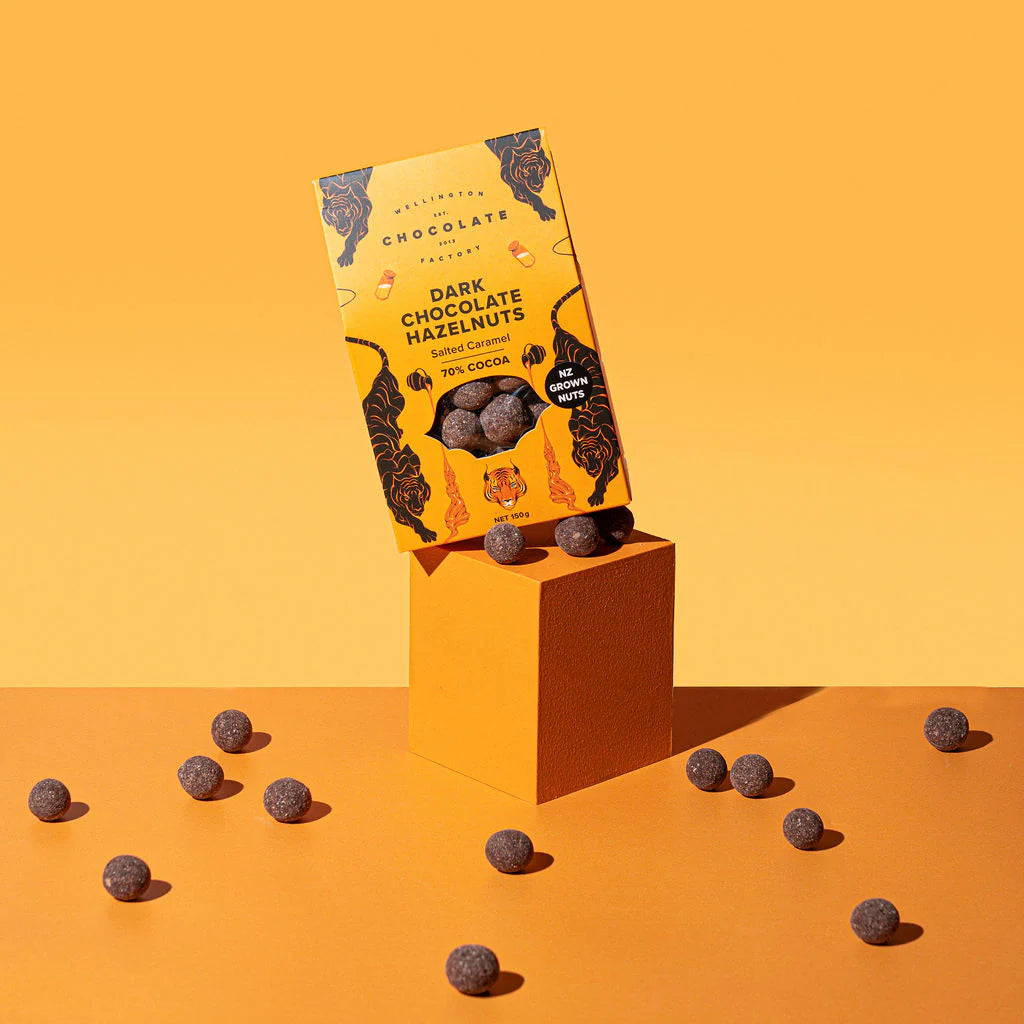 Dark chocolate hazelnuts with packaging on an orange background