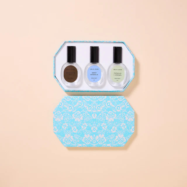 Set of three room spray bottles in a decorative blue box on a beige background