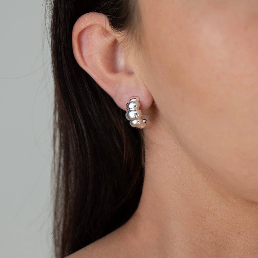 close up of a person wearing a silver earring