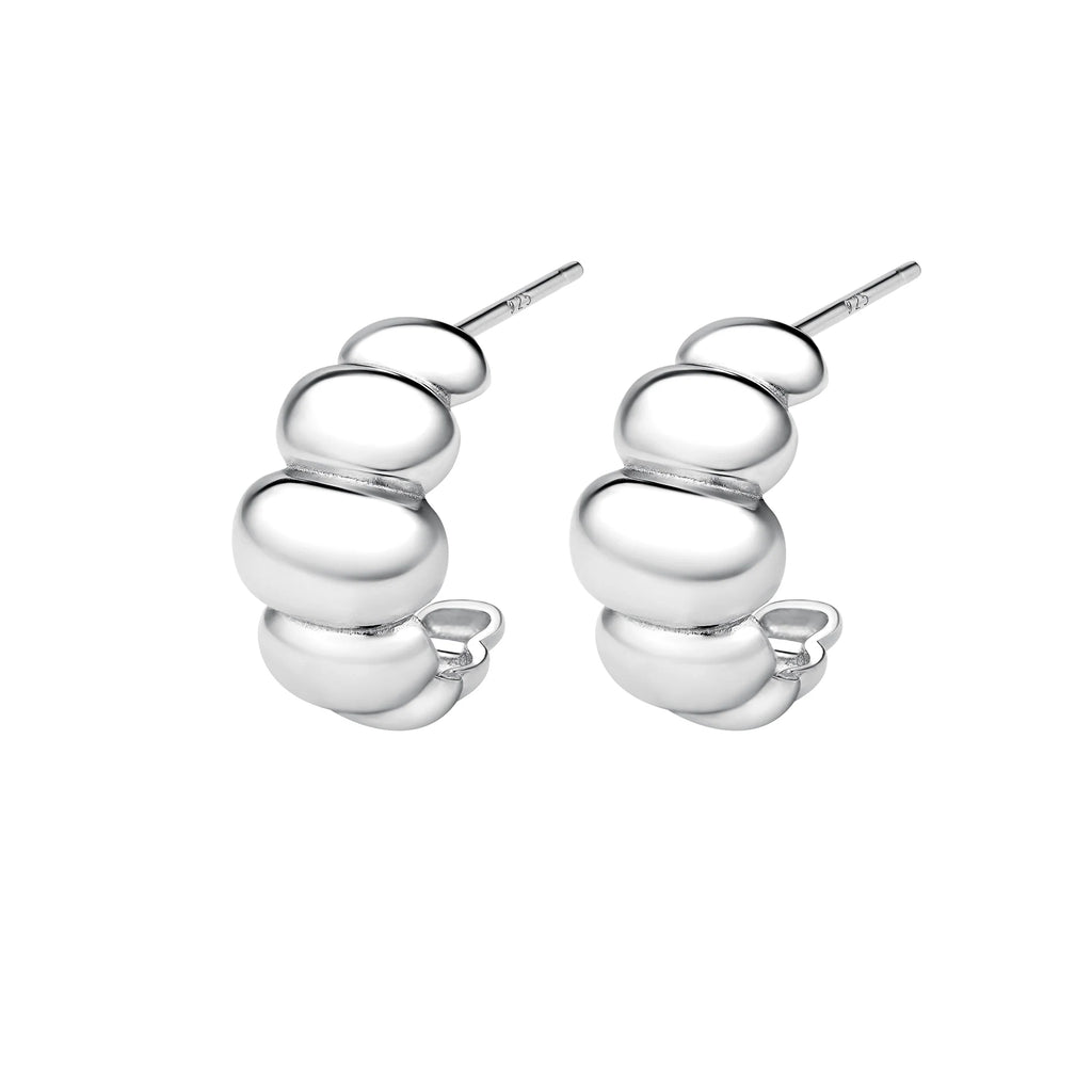 silver huggie earrings against a white background
