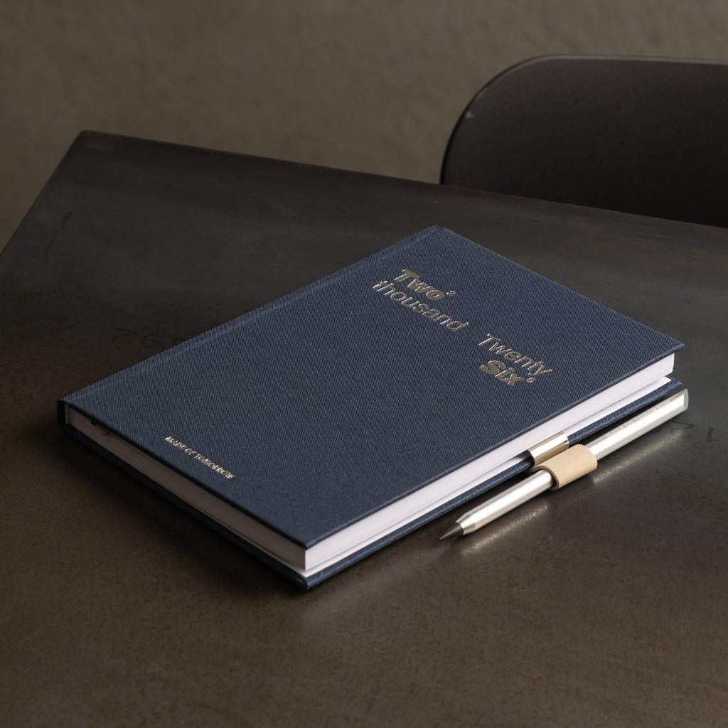 Blue notebook with a pen on a dark surface