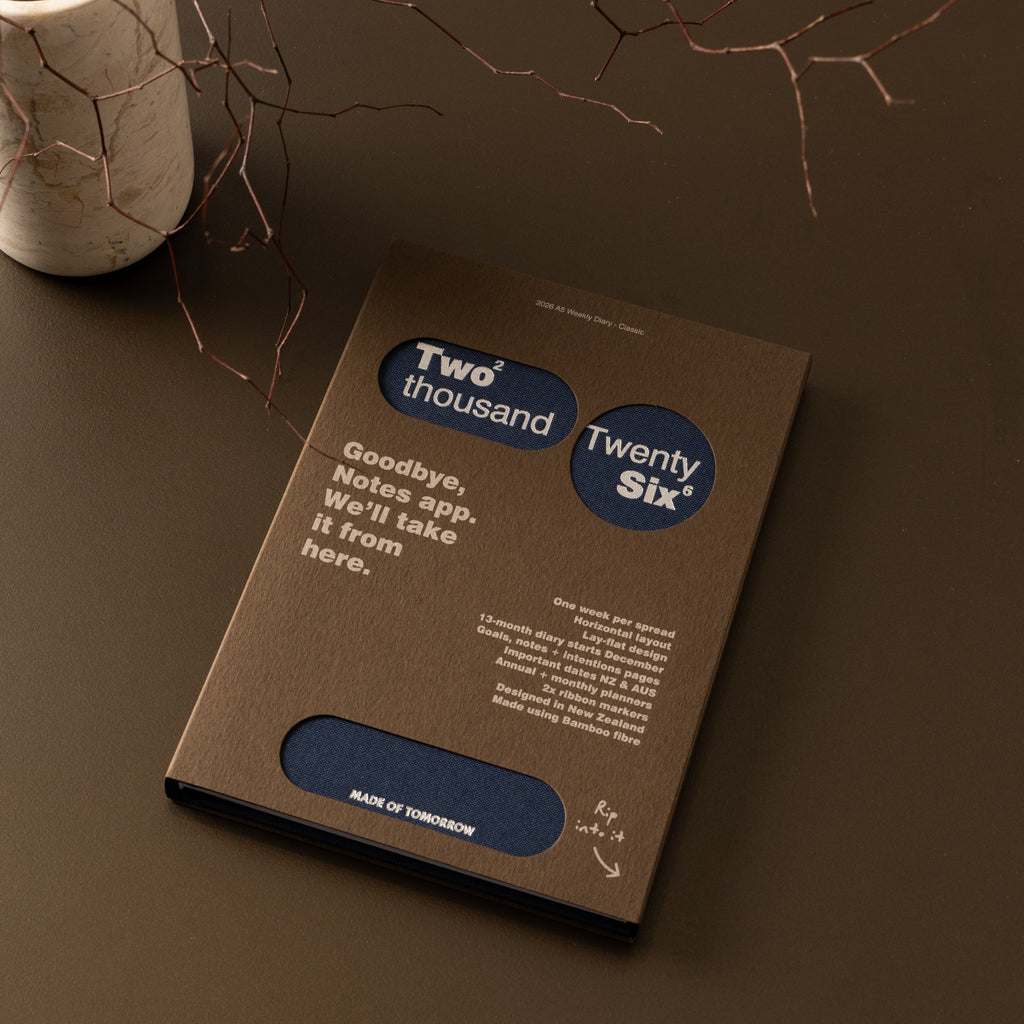 Brown notebook with text and branding on a dark surface