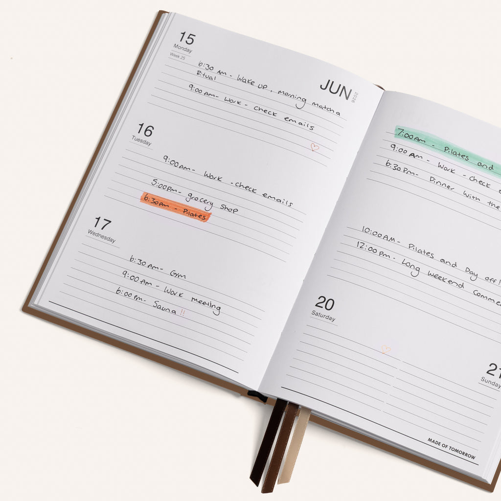 Open daily planner with handwritten tasks and appointments on a white background