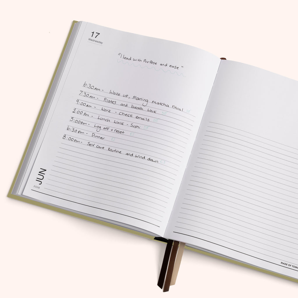 Open planner with handwritten daily schedule on a white background