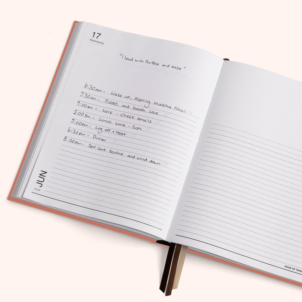 Open planner with handwritten daily schedule on a white background