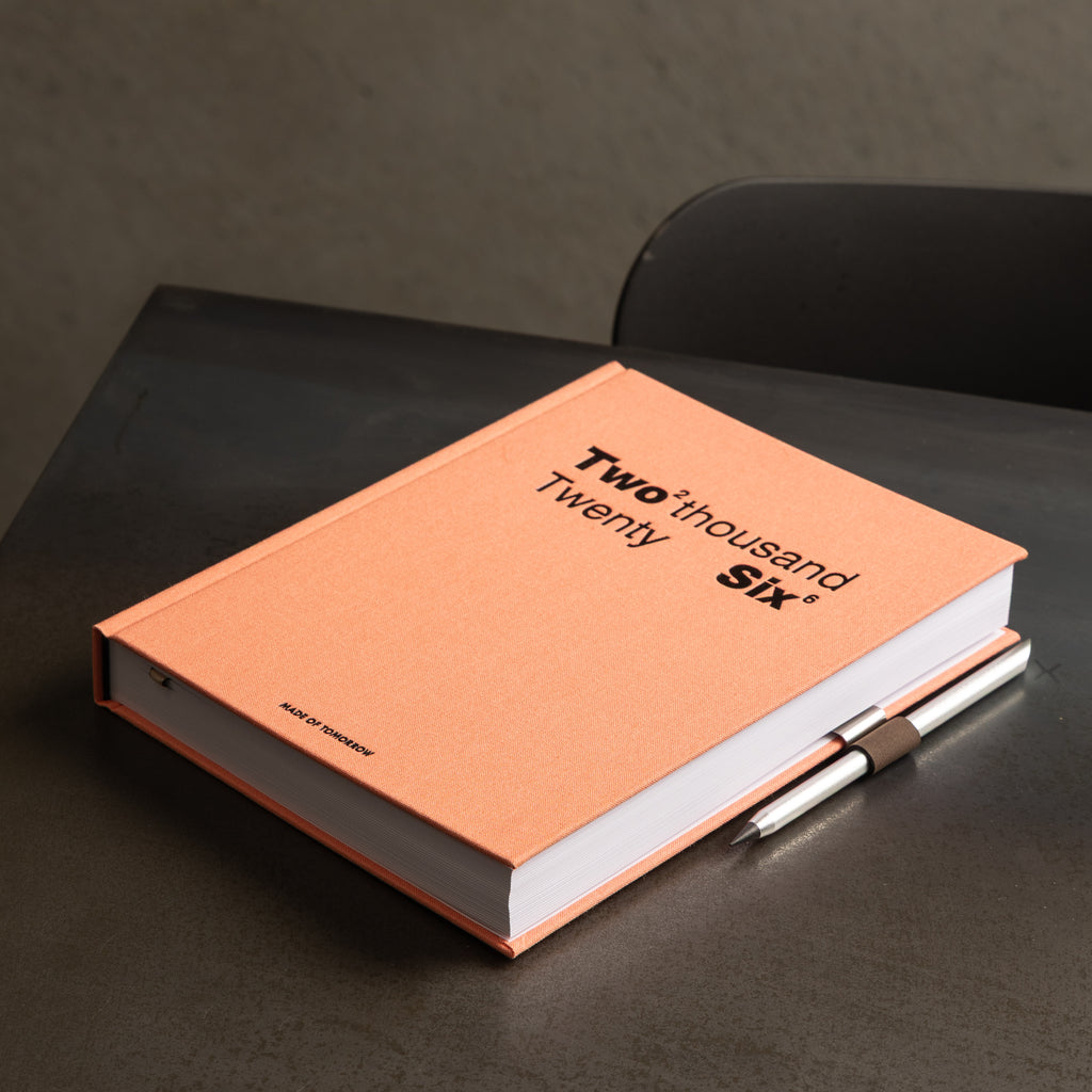 Orange notebook with 'Two Thousand Six' text on a dark surface
