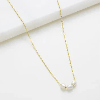 Gold necklace with a pearl pendant on a white background