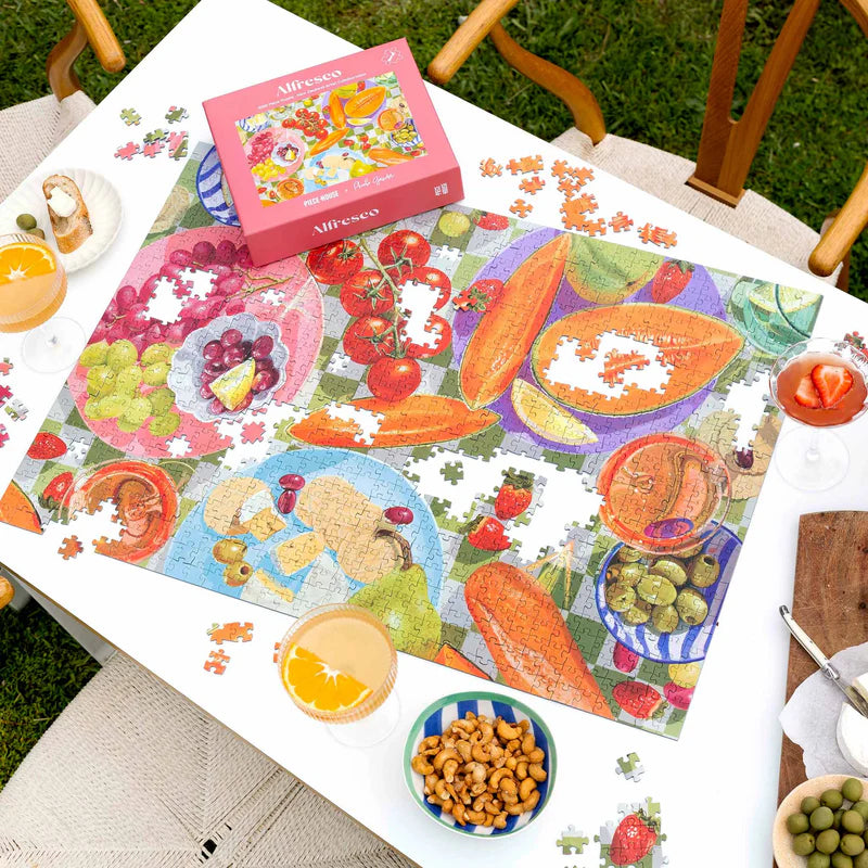 view of a table with food and drinks and a puzzle of colourful fruit