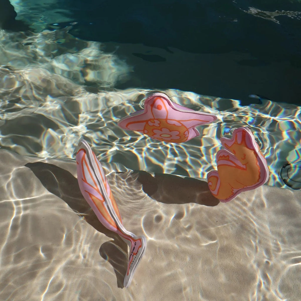 Colorful flip-flops in clear water with a sandy bottom