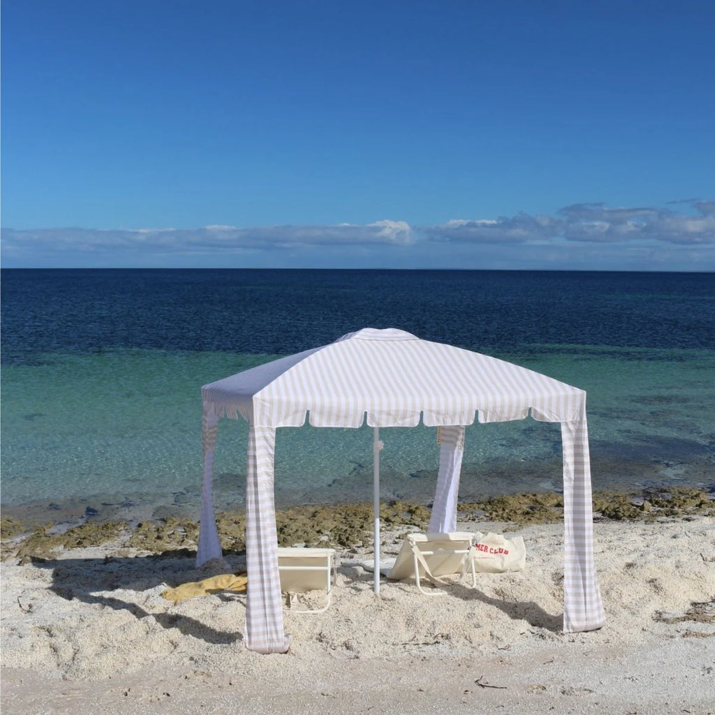 White gazebo on a sandy beach with ocean in the background