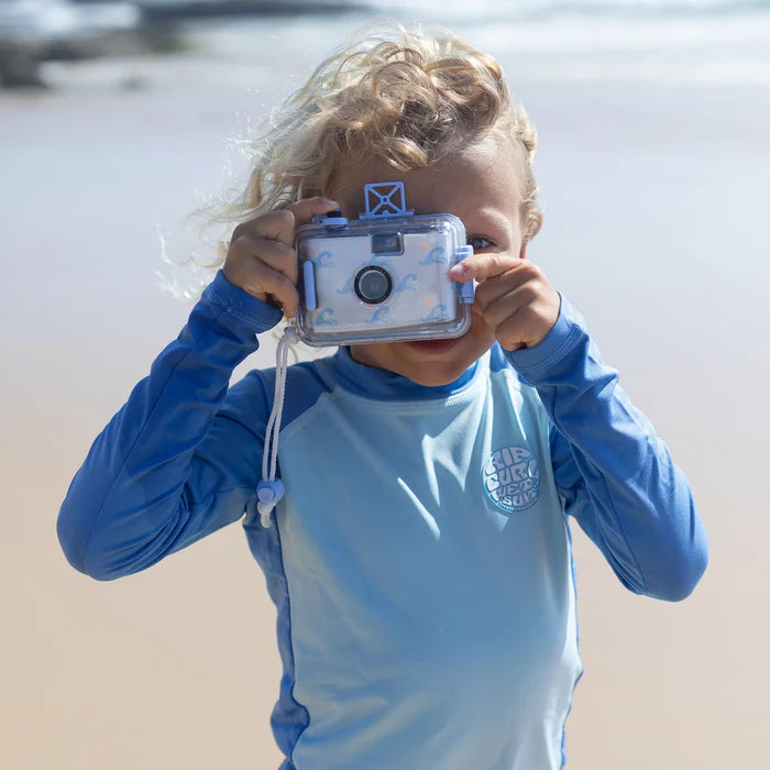 Child holding a waterproof camera on a beach