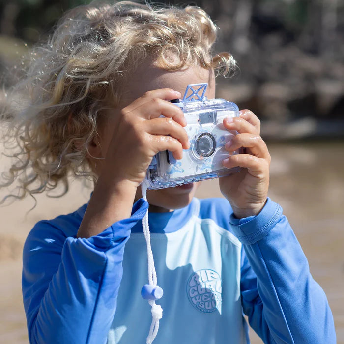 Child holding a clear camera outdoors