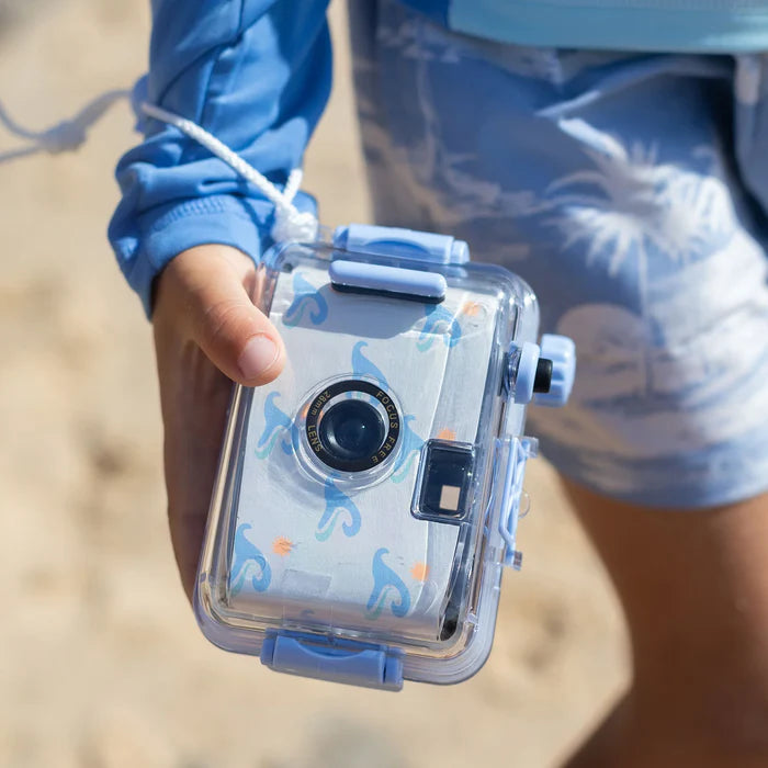 Person holding a waterproof camera with a clear case, outdoor setting
