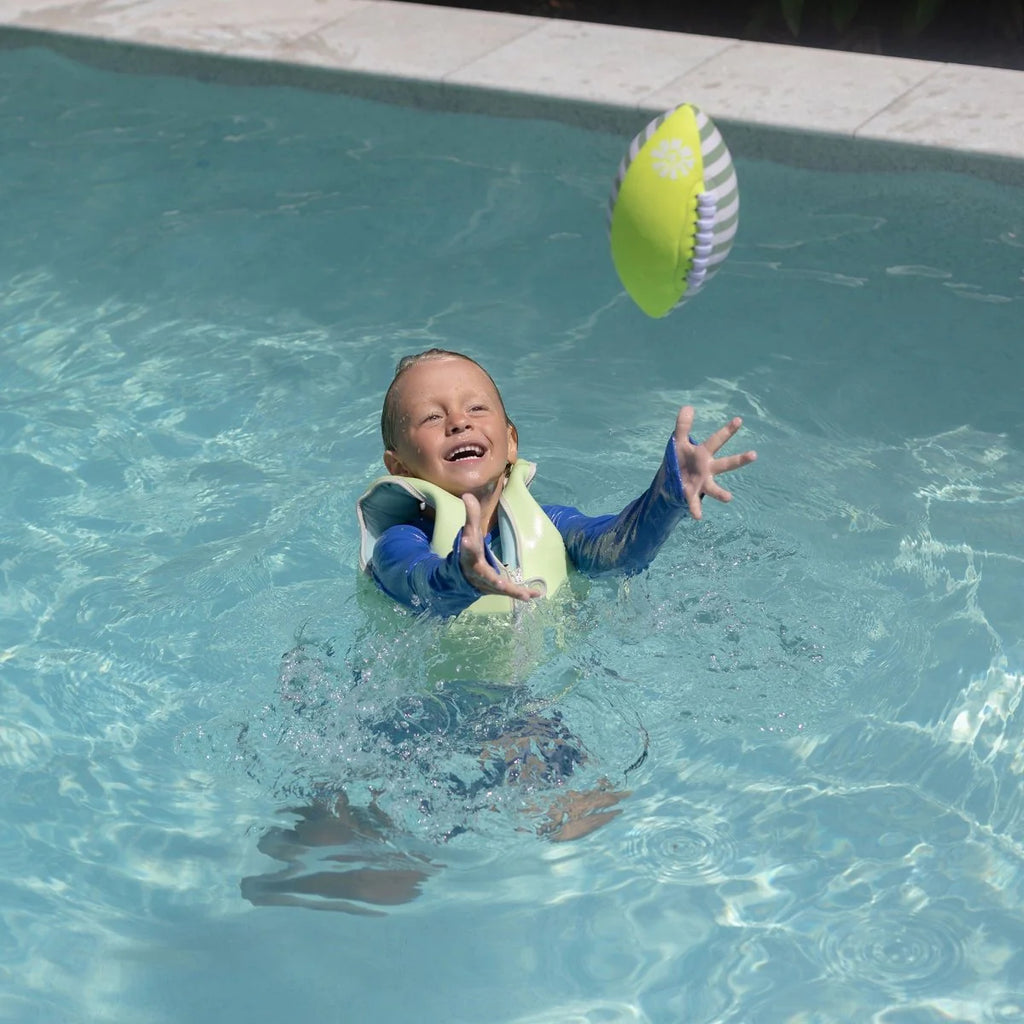 Child playing with a ball in a pool