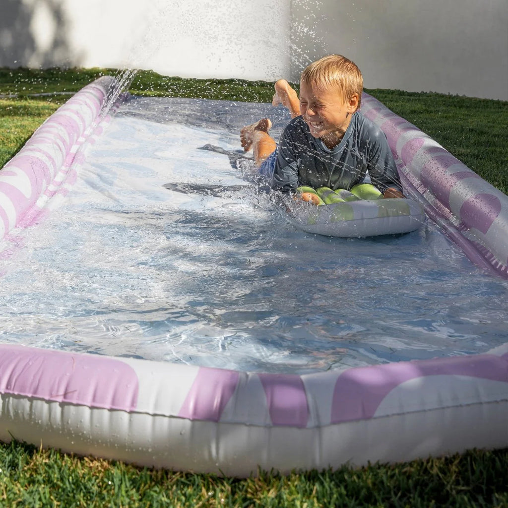 Children playing on an inflatable slide on a grassy area