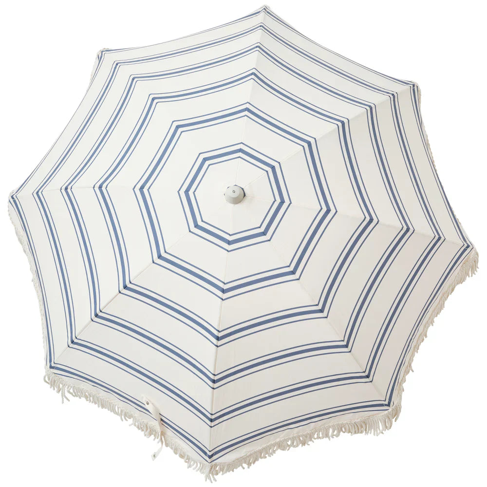 White beach umbrella with blue stripes on a white background